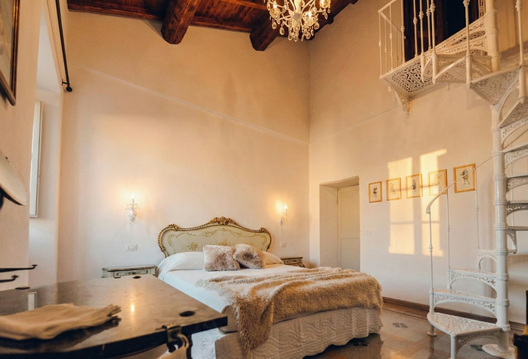 The double-height suite with chandelier and white cast-iron spiral staircase